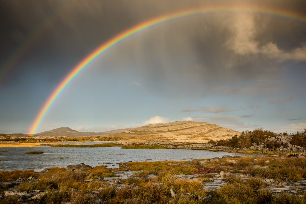 Mullaghmore in the Burren National Park with a bright rainbow above it.