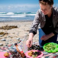 Oonagh preparing a picnic of foraged foods on the beach