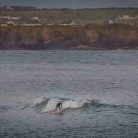 A surfer taking the waves at Spanish Point in County Clare